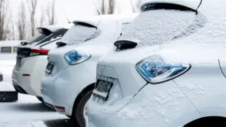 Coches aparcados en la calle nevados