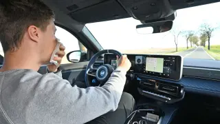 Un conductor sonándose mientras circula