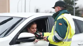 Un agente realizando un control de alcoholemia a una conductora