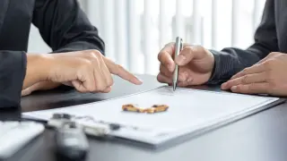 Dos personas firmando el seguro de un vehículo