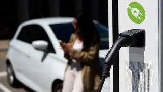 Una conductora cargando su vehículo eléctrico