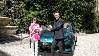 Stella Li, vicepresidenta ejecutiva de BYD, posando junto a uno de los colaboradores del proyecto y un Denza.