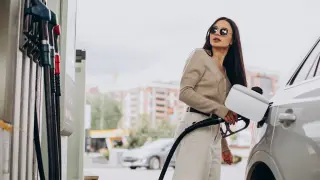 Una mujer suministrando gasolina premium