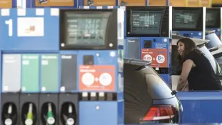 Mujer suministrando gasolina a su vehículo