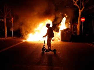 Un hombre conduce un patinete durante las protestas por el juicio del procès en Barcelona, en octubre de 2019.
