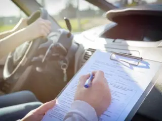 Un examinador de tráfico tomando nota durante un examen.
