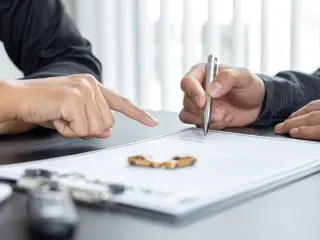 Dos personas firmando el seguro de un vehículo