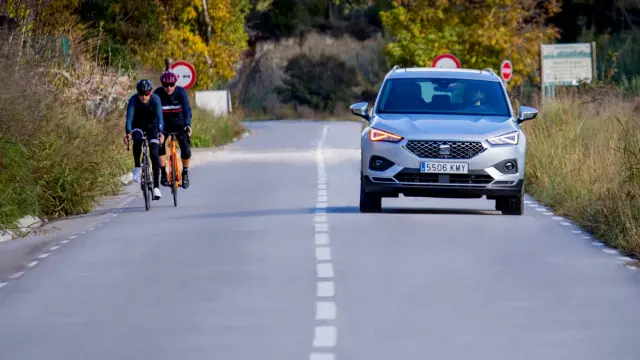 Vehíuclo adelanta a dos ciclistas.