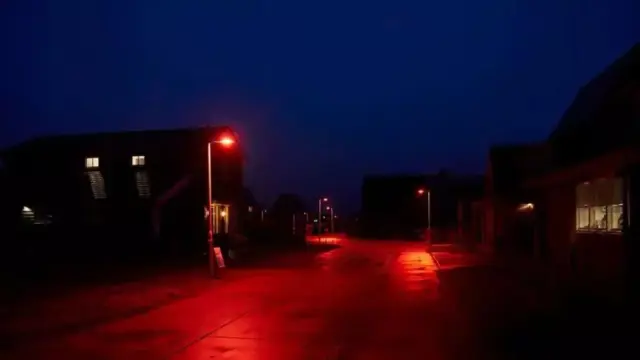 Una calle iluminada por farolas rojas
