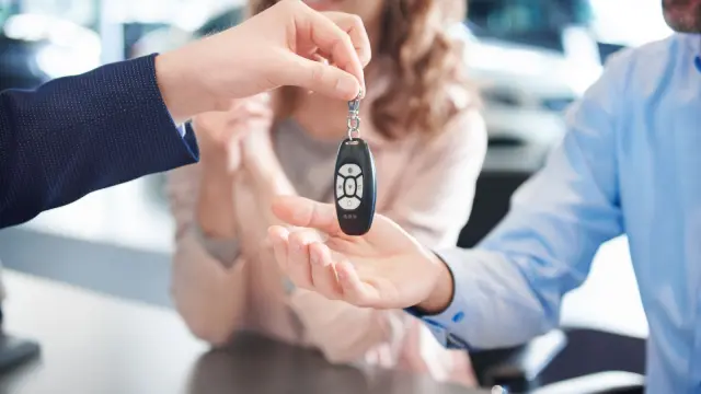 Dos personas comprando un coche en un concesionario