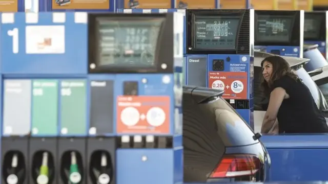 Mujer suministrando gasolina a su vehículo