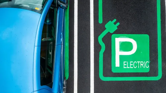 Vehículo eléctrico cargando en un parking