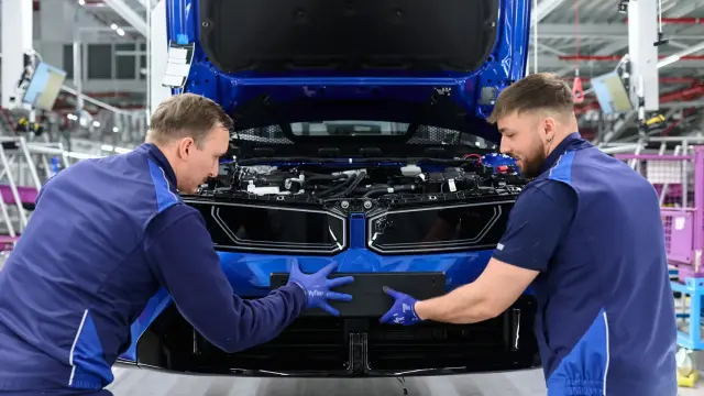 Dos operarios de BMW ensamblan una pieza en la planta de Munich.