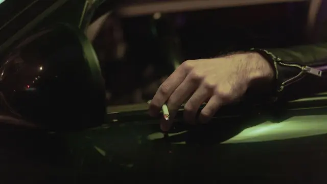 Una persona fumando un cigarrillo mientras conduce