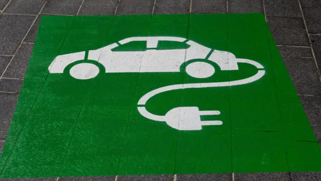Una señal de carga de coche eléctrico pintada en el suelo.