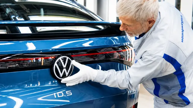 Un trabajador coloca la insignia del grupo en un coche eléctrico en Zwickau.