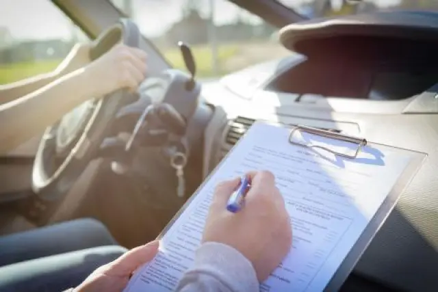 Un examinador de tráfico tomando nota durante un examen.