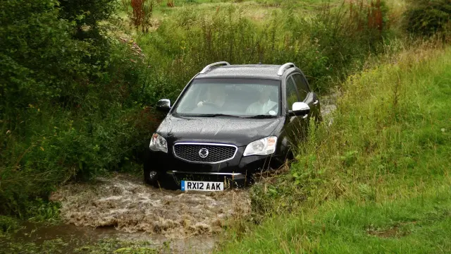 Un coche cruza un camino anegado.