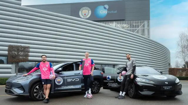 Los jugadores del Manchester City posan con sus nuevos coches eléctricos