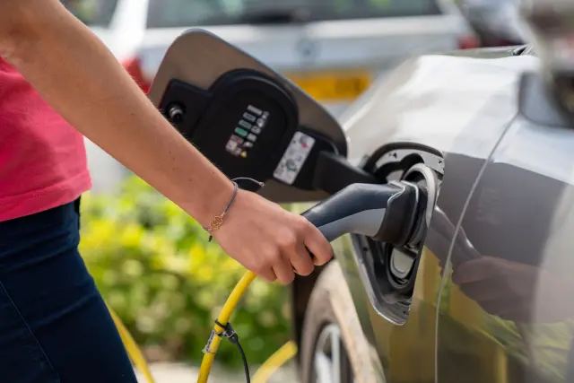 Una persona recargando un coche eléctrico